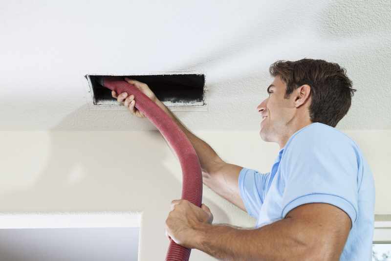 Man cleaning air ducts in home.
